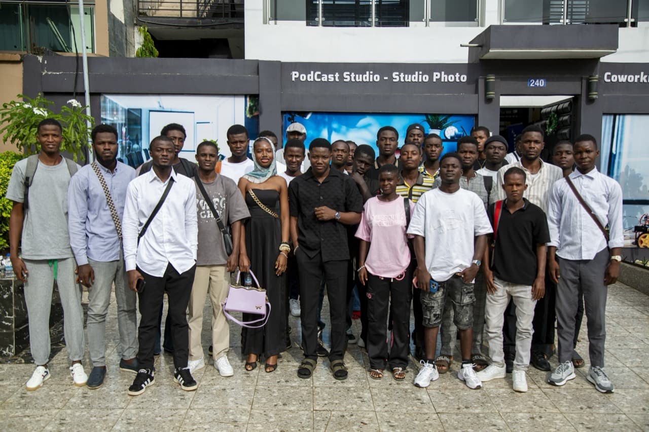 Photo de groupe de la communauté Ivoire Online devant un espace de coworking.